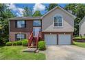 Charming two-story home with brick and stucco exterior, front yard, and two-car garage at 999 Brecken Ln, Lithonia, GA 30058