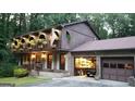 Charming home featuring brick facade, manicured lawn, and unique arched balcony with flower boxes at 4567 Town Crier Sw Rd, Lilburn, GA 30047