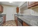 Galley style kitchen features granite countertops, stainless steel appliances and tile flooring at 12303 Waldrop Pl, Decatur, GA 30034