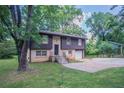 Charming home with a front lawn and driveway surrounded by mature trees and greenery at 1966 Snapfinger Rd, Decatur, GA 30035