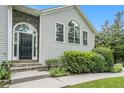 Close-up of the stone-accented entrance with an arched doorway and lush landscaping at 304 Bennett Farms Ct, Acworth, GA 30102