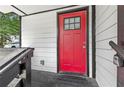 Close-up of a red front door with a glass pane, set against the white siding of a well-maintained house at 951 Reed Ave, Atlanta, GA 30344