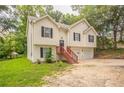 Charming two-story home featuring a two-car garage and a welcoming entrance with wooden stairs at 5069 Jonesboro Rd, Union City, GA 30291