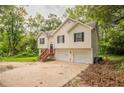 Charming two-story home featuring a two-car garage and a welcoming entrance with wooden stairs at 5069 Jonesboro Rd, Union City, GA 30291