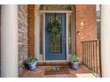 Close-up of a beautiful front door with decorative glass and a wreath, flanked by potted plants at 5575 Julian Pl, Atlanta, GA 30342