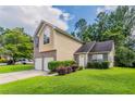 Inviting two-story home featuring a well-manicured front lawn and attached garage at 6207 Idlewood Cir, Lithonia, GA 30038