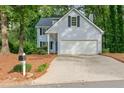House exterior with two-car garage, light blue siding, and traditional design elements at 1420 Fieldgreen Overlook, Stone Mountain, GA 30088