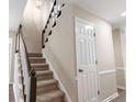 A carpeted staircase with a dark wood railing ascends to the next floor at 1420 Fieldgreen Overlook, Stone Mountain, GA 30088
