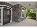 Inviting front porch with stone accents, a stylish door, and a cozy outdoor space at 308 Shade Tree Cir, Woodstock, GA 30188