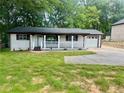 Well-kept home featuring a covered porch, attached garage and ample front yard space at 256 New Hope Rd, Lawrenceville, GA 30046