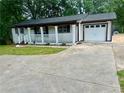 Home with a front porch, attached garage, and a wide driveway at 256 New Hope Rd, Lawrenceville, GA 30046