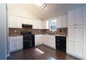 Bright kitchen with white cabinets, black appliances, and a stylish backsplash, offering a modern and functional space at 2333 Wilkins Cv, Decatur, GA 30035
