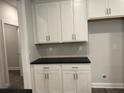 Kitchenette with black countertops, white cabinets, and subway tile backsplash at 3383 Milan Ct, Douglasville, GA 30135