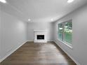 Bright living room with neutral gray walls, a cozy fireplace, and gleaming wood floors at 3867 Cherie Glen Rd, Snellville, GA 30039