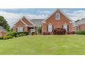 Traditional red brick home with black shutters and green lawn, showcasing classic design at 995 Lewis Ridge Cir, Lawrenceville, GA 30045
