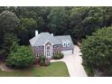 Aerial view of a two-story red brick home with a large, manicured lawn surrounded by lush trees at 1858 De Winton Pl, Lawrenceville, GA 30043