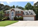 Two-story brick home featuring a well-manicured lawn and an attached two-car garage in a desirable neighborhood at 1858 De Winton Pl, Lawrenceville, GA 30043