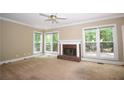 Spacious living room featuring a classic brick fireplace, neutral paint, and large windows overlooking the backyard at 1858 De Winton Pl, Lawrenceville, GA 30043