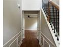 Hallway with rich wood floors, staircase with iron spindles, and wainscoting, offering a grand entrance to the home at 2423 Turnbury Glen Walk, Snellville, GA 30078