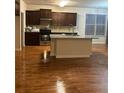 Spacious kitchen with granite countertops, an island, stainless steel appliances, and hardwood flooring at 2423 Turnbury Glen Walk, Snellville, GA 30078