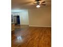 Bright living room featuring hardwood flooring, a ceiling fan, and large windows offering natural light at 2423 Turnbury Glen Walk, Snellville, GA 30078