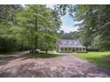 Beautiful home with a long driveway, mature trees, and inviting front porch for relaxing at 3743 Johnston Rd, Winston, GA 30187