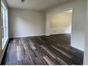 Bright living room with dark wood-look floors and abundant natural light at 11800 Carriage Park Ln, Johns Creek, GA 30097