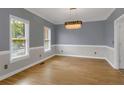 Dining room featuring wood floors, modern lighting, and natural light from dual windows at 140 Heritage Ct, Fayetteville, GA 30214