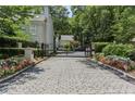 Secure gated entrance with cobblestone drive leading to the property, surrounded by lush landscaping at 2466 Brookhaven Ne Pl, Brookhaven, GA 30319