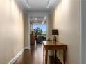 Inviting hallway featuring a console table, hardwood floors, and a glimpse into the bright living area at 2660 Peachtree Nw Rd # 13F, Atlanta, GA 30305
