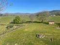 Spacious backyard with a rustic fence, trampoline, shed, fire pit, and scenic mountain views at 30 Ne Moriah Way Ne Way, Rydal, GA 30171