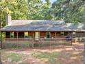 Charming home with a covered front porch, perfect for relaxing, and surrounded by lush greenery at 1000 Coan Dr, Locust Grove, GA 30248