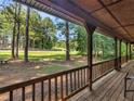 Scenic view from the covered front porch overlooking a spacious front yard with mature trees at 1000 Coan Dr, Locust Grove, GA 30248