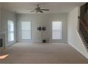 Spacious living room featuring neutral walls, carpet, fan, fireplace, and staircase at 2118 Water Mill Ct, Buford, GA 30519