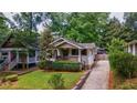 Quaint home with lush landscaping, a driveway and a welcoming front porch at 91 Rogers Se St, Atlanta, GA 30317
