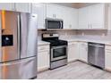 Modern kitchen with stainless steel appliances, white cabinets, and light countertops at 1282 Harris Commons Pl, Roswell, GA 30076