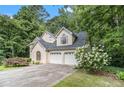 Attached two-car garage with white doors and lush landscaping at 3420 Cranborne, Marietta, GA 30062