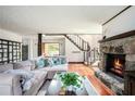 Inviting living room featuring hardwood floors, a stone fireplace, and staircase access at 3611 Winfair Pl, Marietta, GA 30062