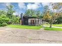 Modern ranch-style home with black exterior, bright orange front door, covered porch, and beautiful landscaping at 851 Flagler Se Cir, Smyrna, GA 30080