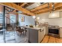 Open-concept kitchen with island seating, stainless steel range, exposed brick, and spiral staircase at 63 Mangum Sw St # 3, Atlanta, GA 30313