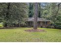 An eye-level view of this single story brick home showcasing the large front lawn, shady tree, and paved walkway at 1206 Tuckawanna Sw Dr, Atlanta, GA 30311