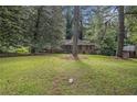 A wide shot of this brick home with a well-manicured front lawn, mature trees, and partial shade at 1206 Tuckawanna Sw Dr, Atlanta, GA 30311