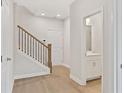 Bright hallway featuring beautiful hardwood floors and stylish staircase with white trim and iron spindles at 1991 Deco Dr, Kennesaw, GA 30144
