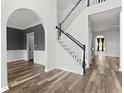 Bright entryway featuring wood floors, an elegant staircase, and neutral paint colors throughout at 3520 Mystic Dr, Buford, GA 30519