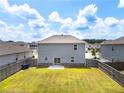Large grassy backyard with a wood privacy fence and sliding glass doors to the house at 3660 Cattle Field Xing, Loganville, GA 30052