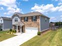 View of a two story brick home showing the driveway and an attached two-car garage at 3660 Cattle Field Xing, Loganville, GA 30052