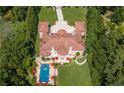 An aerial view of the luxurious estate with pool, manicured grounds and red umbrellas at 720 Heards Ferry Rd, Sandy Springs, GA 30328