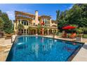 Luxurious backyard featuring a large swimming pool, lounge chairs, and manicured landscaping at 720 Heards Ferry Rd, Sandy Springs, GA 30328