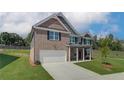 Elegant two-story brick home with a spacious layout, featuring a well-maintained lawn and an attached garage at 1816 Kingsmere Run Dr, Loganville, GA 30052