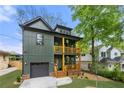 Charming home featuring a two-story porch, green siding and a convenient attached garage at 224 Cambridge Avenue, Decatur, GA 30030